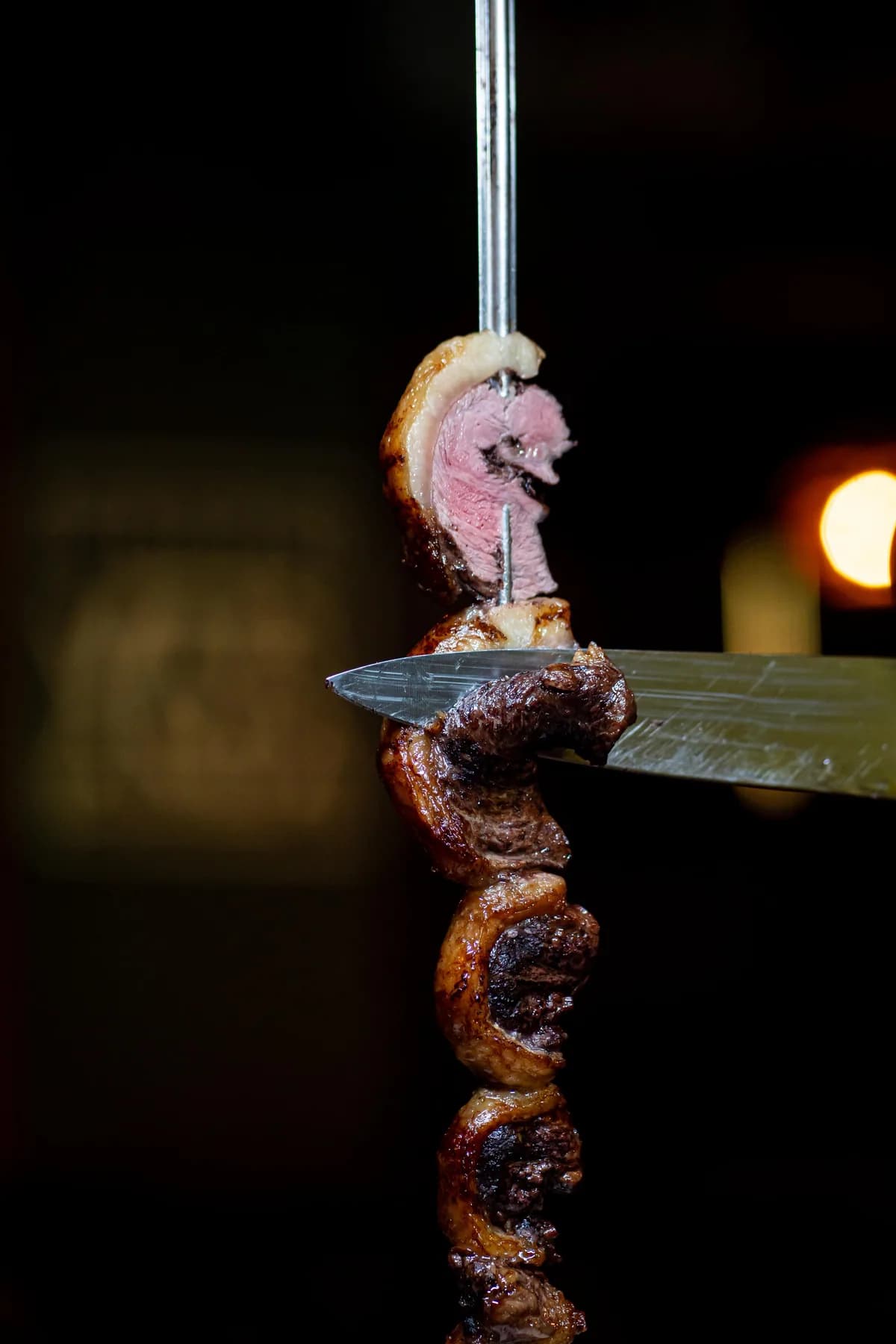 Picanha sendo fatiada diretamente do espeto